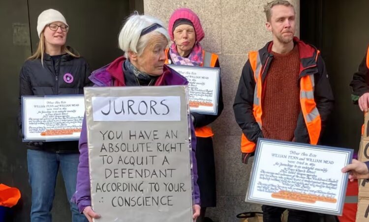 Judge throws out case against UK climate activist who held sign on jurors’ rights